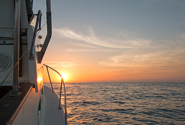 Fishermans view of yellowish orange sunrise over the Sea of Cortes / Gulf of California while fishing in the early morning south of Cabo Pulmo and just north of San Jose Del Cabo and Cabo San Lucas Baja Mexico BCS